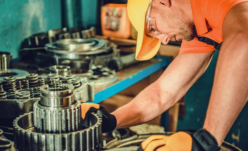 Mechanic inspecting an oil ring in a gearbox.