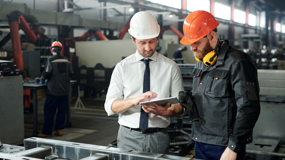 Manufacturing colleagues reviewing data in an industrial environment