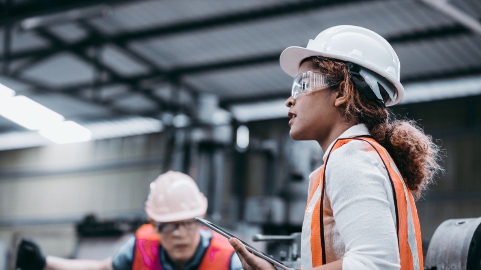 Employees wearing safety gear in a manufacturing facility