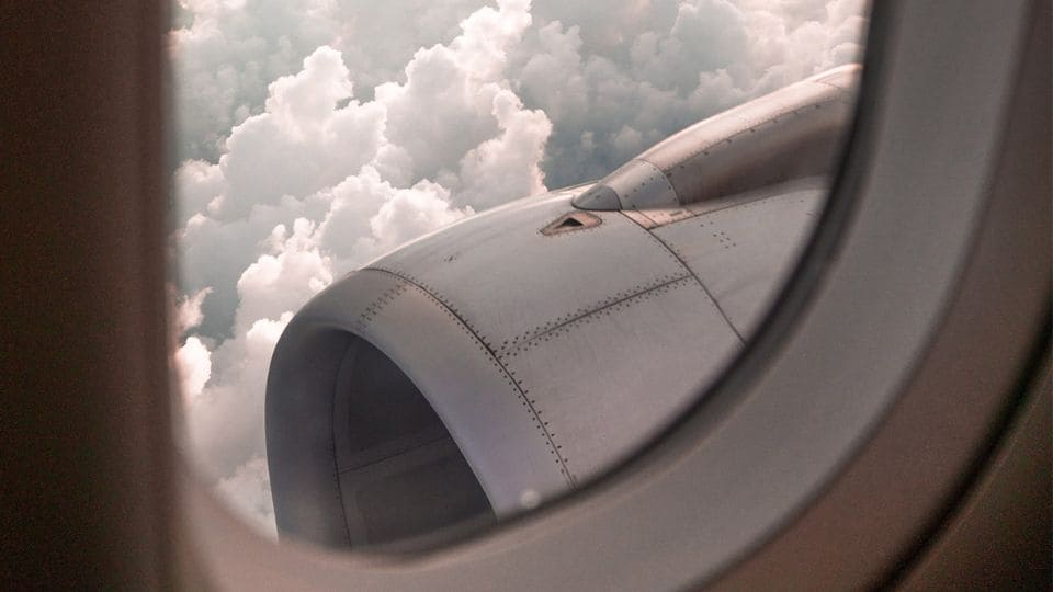 Blick aus einem Passagierfenster auf eine Flugzeugturbine