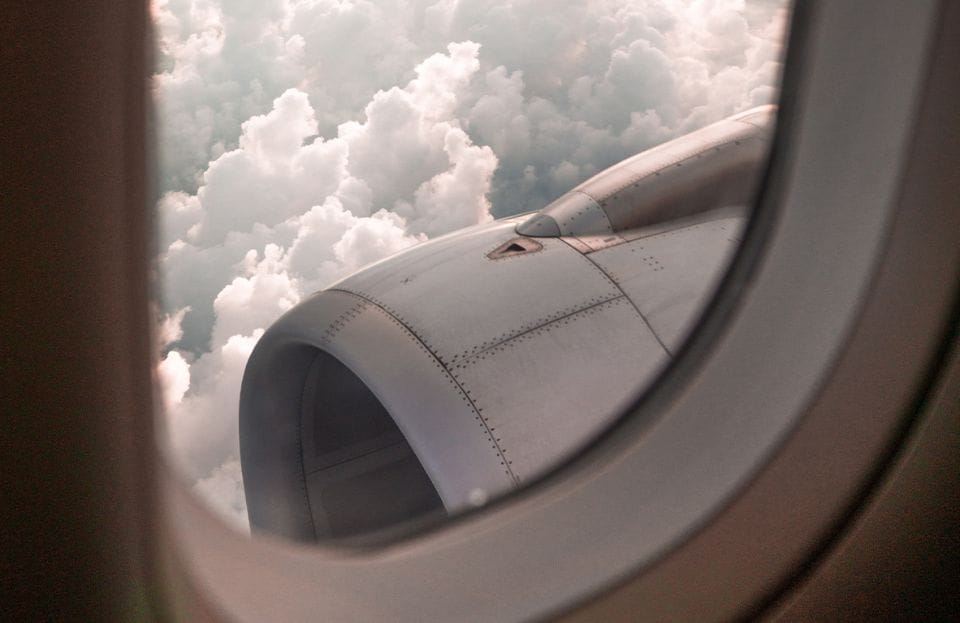 Blick aus einem Passagierfenster auf eine Flugzeugturbine